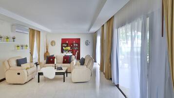A modern living room with two sofas, a coffee table, and a bookshelf.