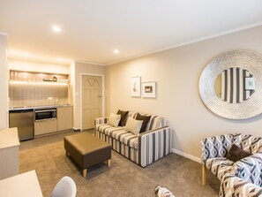 Premium One Bedroom | Coin séjour | Télévision à écran plat de 50 pouces avec chaînes par câble, télévision