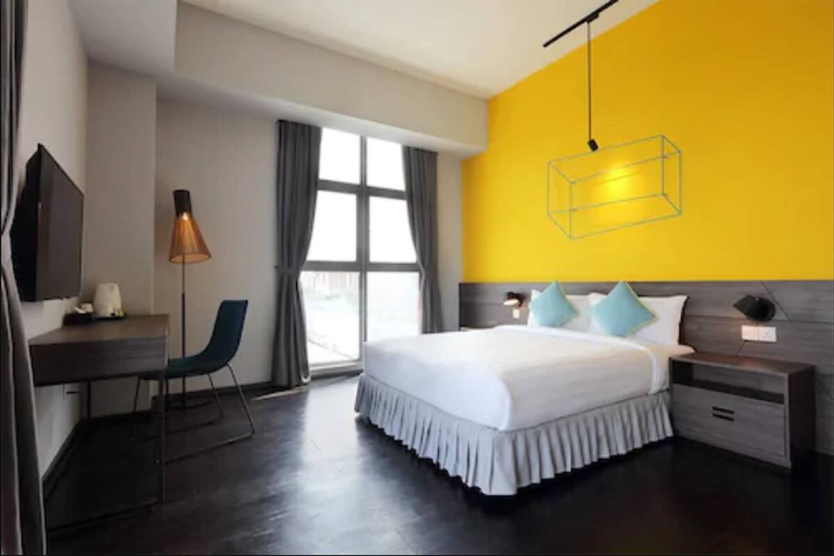 Een moderne hotelkamer met een groot bed, een bureau en een stoel.