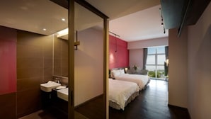 A modern hotel room with a large bed, a separate bathroom with two sinks, and a view of the outdoors through a large window. - FEECO HOTEL KUALA LUMPUR (Kuala Lumpur)