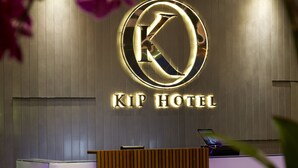 A reception desk with a modern design, a logo above the desk, and a wooden panel wall. - FEECO HOTEL KUALA LUMPUR (Kuala Lumpur)