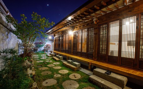 A traditional Japanese-style building with tatami mat flooring and a wooden bench along the side.