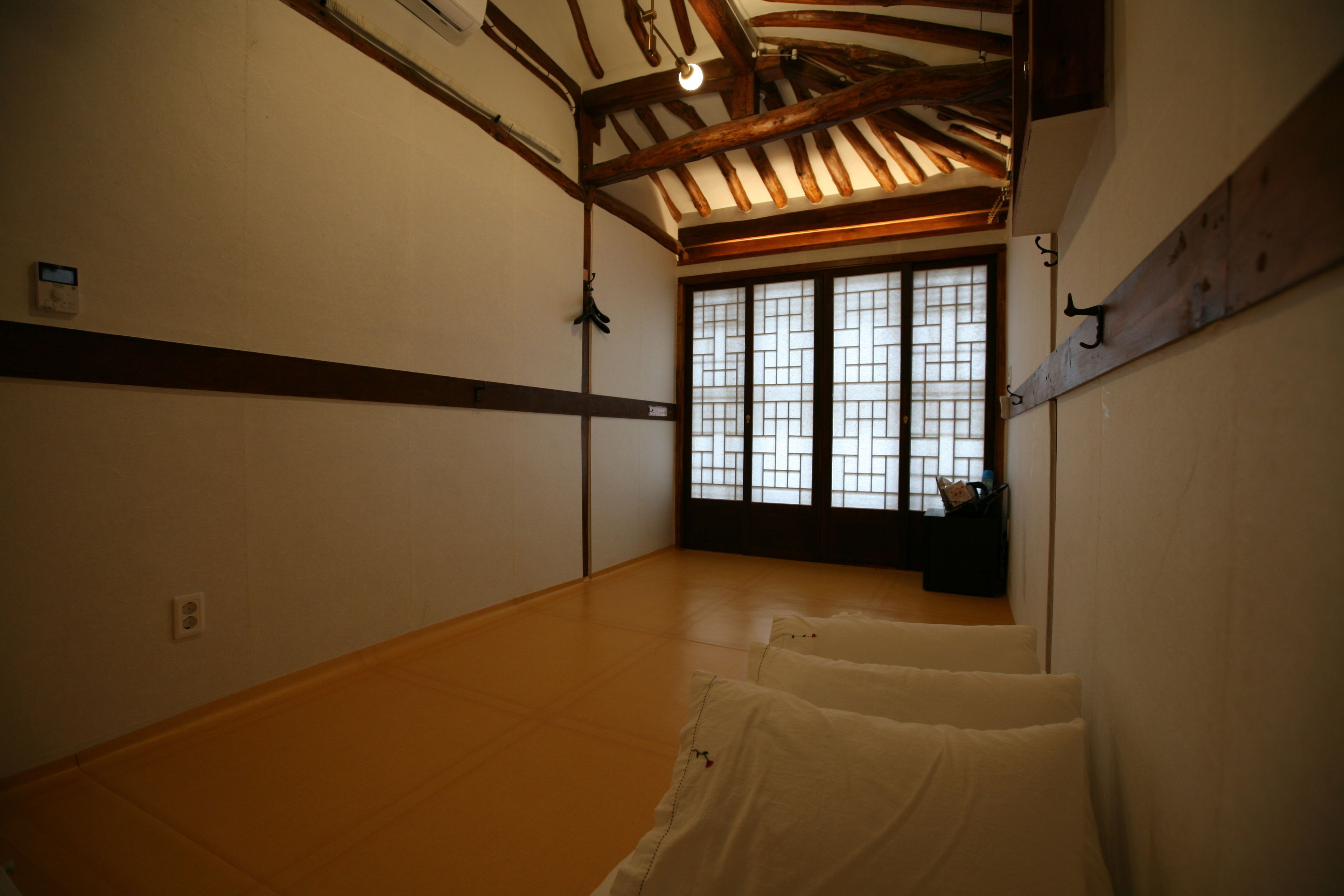 Een traditionele Japanse kamer met tatami vloerbedekking, een shoji-schrijn en een houten plafond.