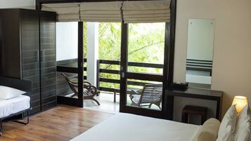 A bedroom with a bed, a wardrobe, a desk with a lamp, and a balcony with a chair.
