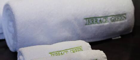 Two rolled towels with the text "Terrace Green" on them, placed on a dark surface.