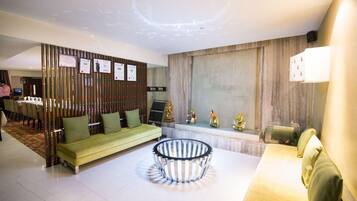 A modern living room with a green sofa, a round coffee table, and a decorative wall with plaques.