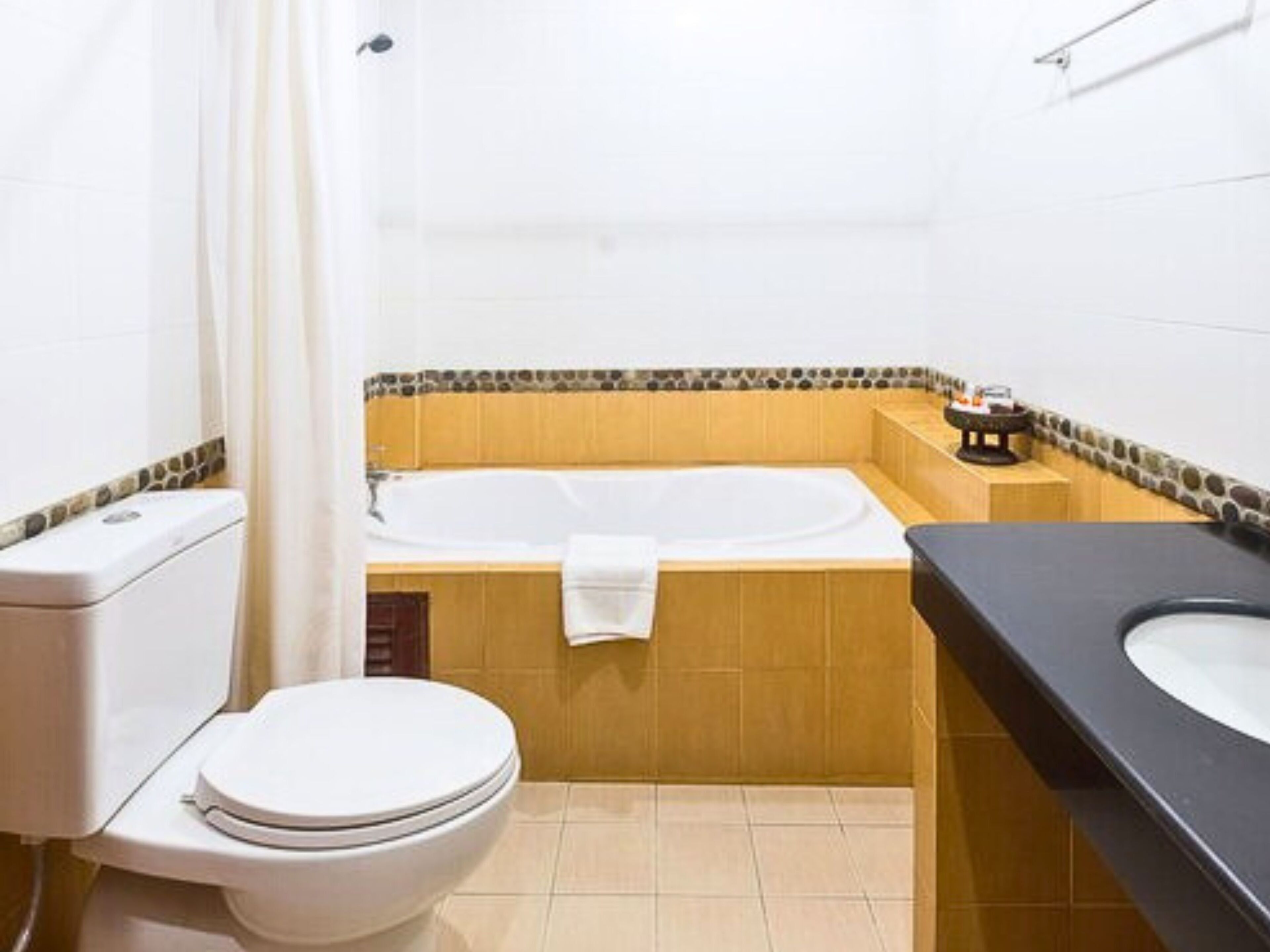 A bathroom with a toilet, bathtub, and sink.