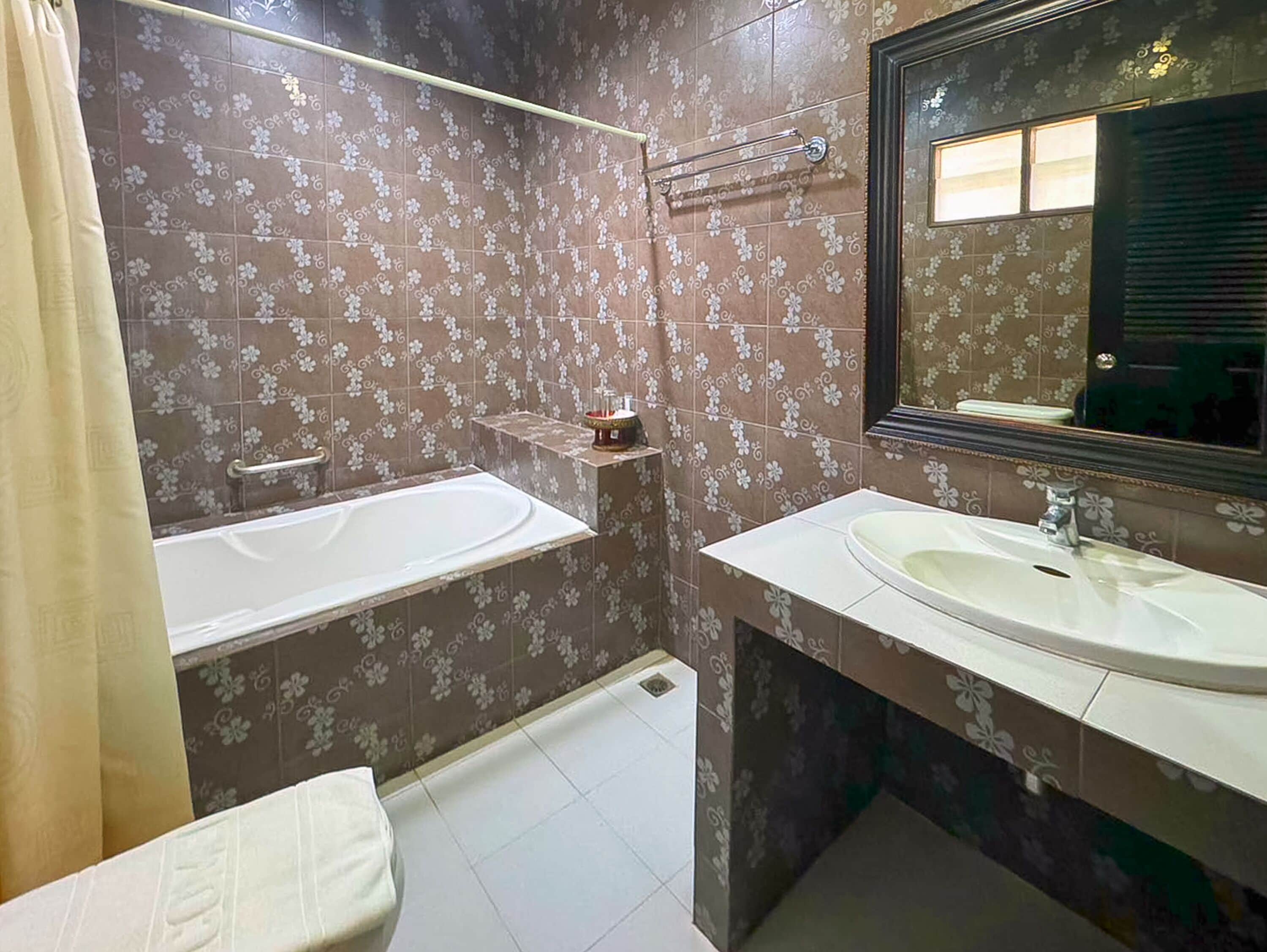 A bathroom with a bathtub, a sink, and a mirror.