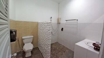 Un baño con inodoro, ducha y lavamanos.