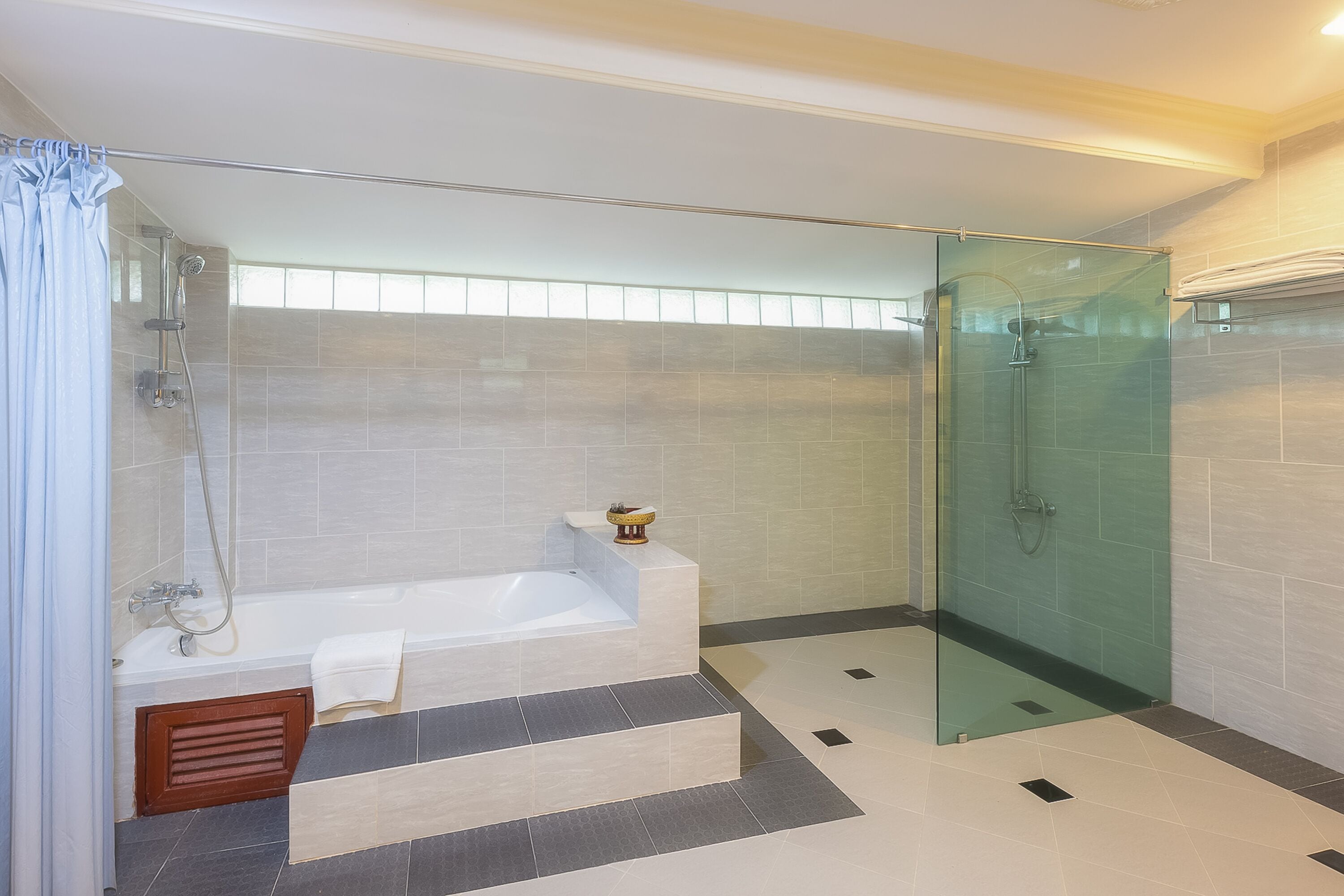 A modern bathroom with a glass-enclosed shower, a standalone bathtub, and a vanity with a towel.