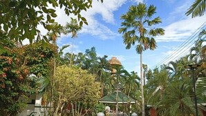 A tropical garden with a gazebo, palm trees, and a fountain. - Silamanee Resort and Spa Hotel (Mae Sai)