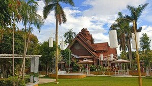 A hotel with a large, brown building and a well-maintained lawn. - Silamanee Resort and Spa Hotel (Mae Sai)