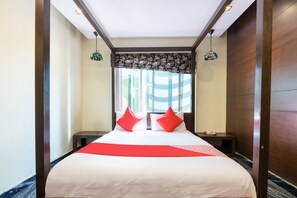 A hotel room with a large bed, two nightstands, a telephone, and a window with striped curtains. - OYO 852 Kings 10 (Bengaluru)
