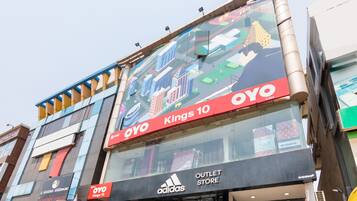 Un edificio de varios pisos con una tienda outlet Adidas en la planta baja.