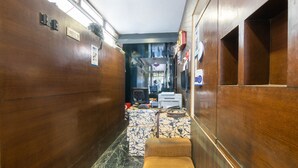 A narrow hallway with wooden walls, a patterned rug, and a small seating area with a bench. - OYO 852 Kings 10 (Bengaluru)