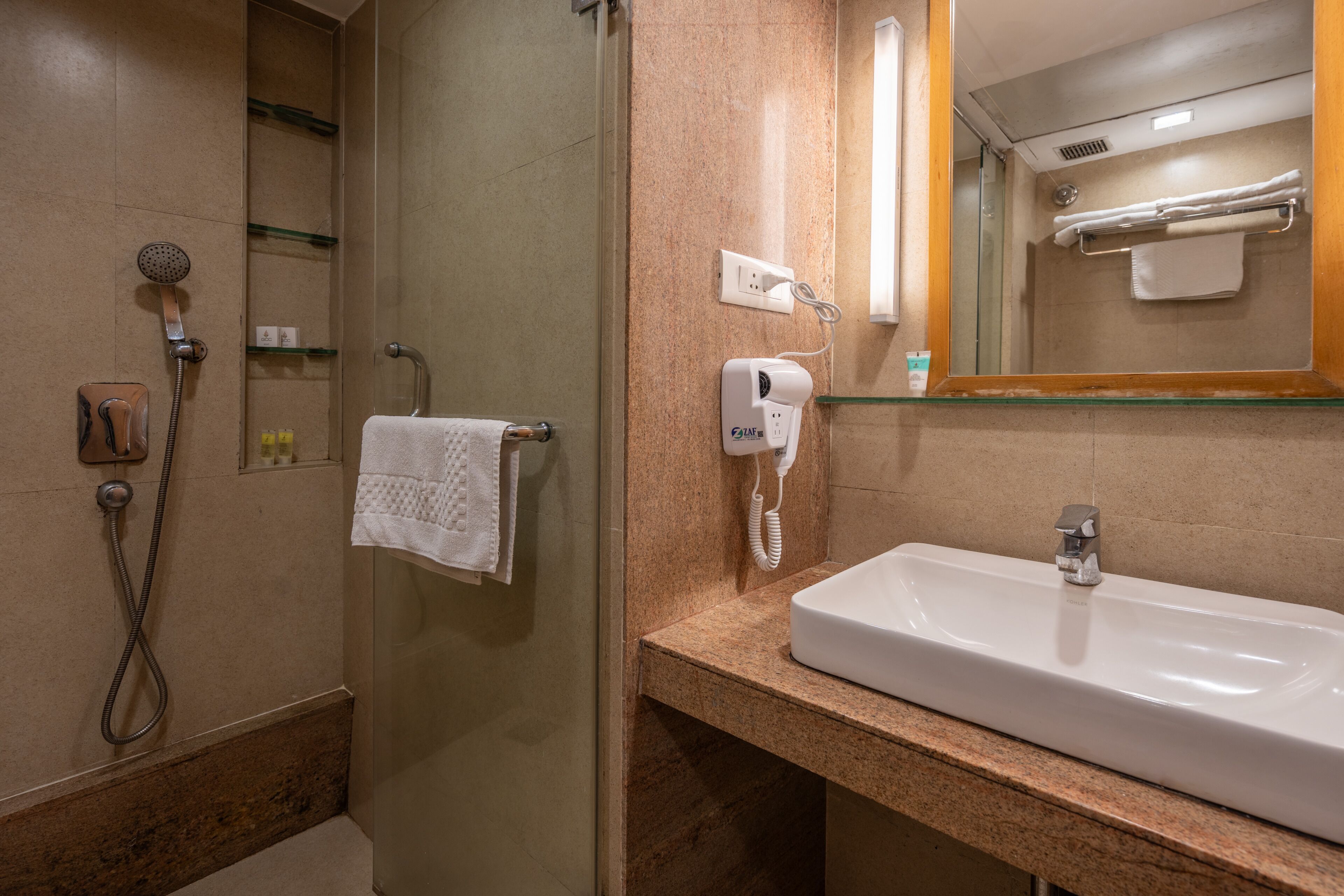 A bathroom with a shower, a sink, a towel rack, and a mirror.