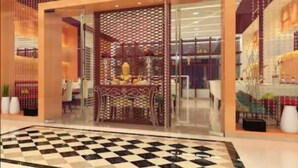 A hotel lobby with a checkered floor, a decorative glass partition, and a seating area with a table and chairs. - GCC Northside Hotel (Mumbai)