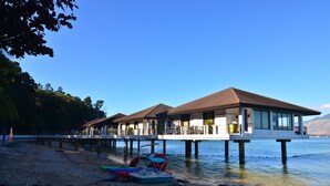 A waterfront hotel with overwater bungalows, a sandy beach, and boats. - Hotel Kamana Sanctuary Resort and Spa (Morong)