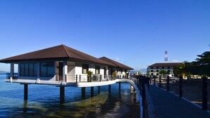 A waterfront building with a balcony, supported by pillars, overlooking a body of water. - Hotel Kamana Sanctuary Resort and Spa (Morong)