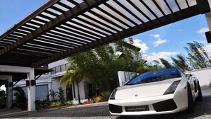 A white sports car parked under a modern structure with a metal roof. - Hotel Kamana Sanctuary Resort and Spa (Morong)