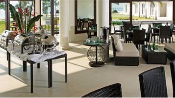 A spacious lobby with a seating area, a coffee station, and a view of the outdoors.