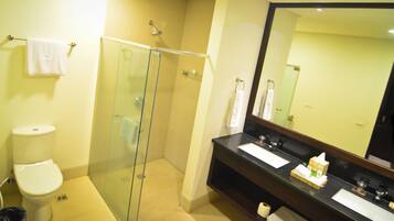 Ein Badezimmer mit einer Duschkabine, Toilette, Waschbecken mit Spiegel und Handtuchhalter.