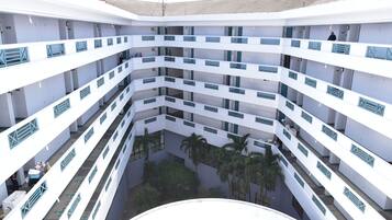 A multi-level atrium with balconies and palm trees.