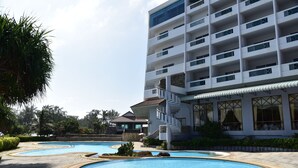 A hotel with multiple swimming pools, a modern building with balconies, and a landscaped garden area. - BP Samila Beach Hotel & Resort (Songkhla)