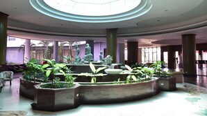 A spacious lobby with a central fountain, large columns, and a skylight. - BP Samila Beach Hotel & Resort (Songkhla)