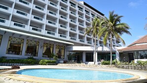 A hotel with a large pool, multiple balconies, and palm trees. - BP Samila Beach Hotel & Resort (Songkhla)