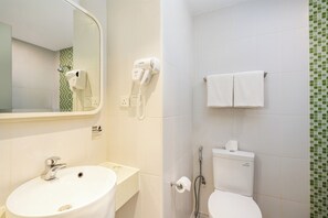 A bathroom with a sink, mirror, towel rack, toilet, and a shower. - Zest Harbour Bay Batam by Swiss-Belhotel International (Batam)