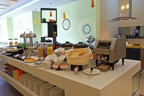 A buffet area with various food stations, including a coffee machine and a basket of bread. - Zest Harbour Bay Batam by Swiss-Belhotel International (Batam)