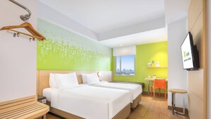 Una habitación de hotel con dos camas, una mesa de madera, un televisor y vistas a la ciudad.