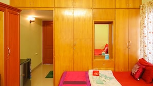 A bedroom with a bed, a wardrobe, and a mirror.