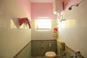 Un baño pequeño con inodoro, ducha y ventana.
