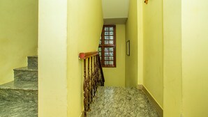 A staircase with marble steps and wooden railings leading to a room with a window.
