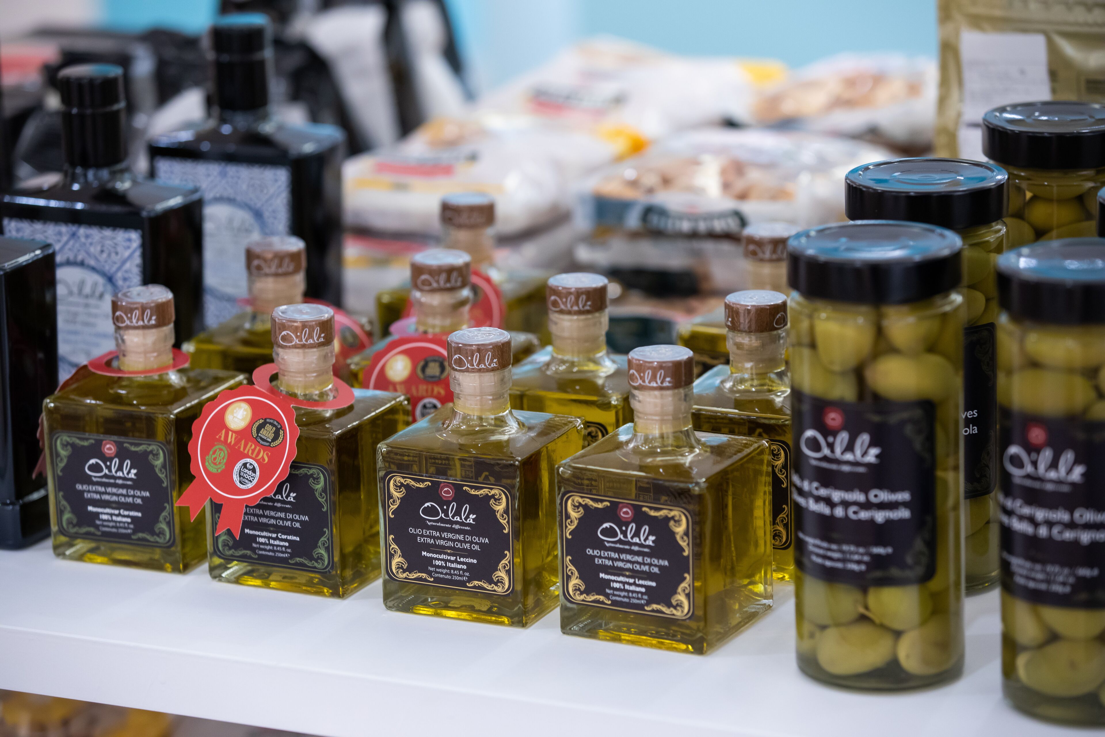 Des bouteilles d’huile d’olive extra vierge sont posées sur une étagère.
