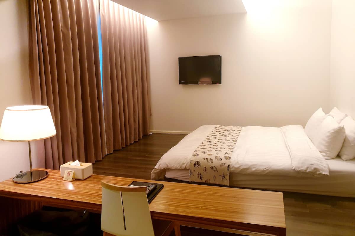 Minibar, escritorio, cortinas blackout y tabla de planchar con plancha