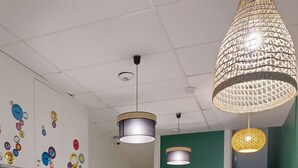 Un área de recepción con un mostrador de madera, una pared verde y una escalera.