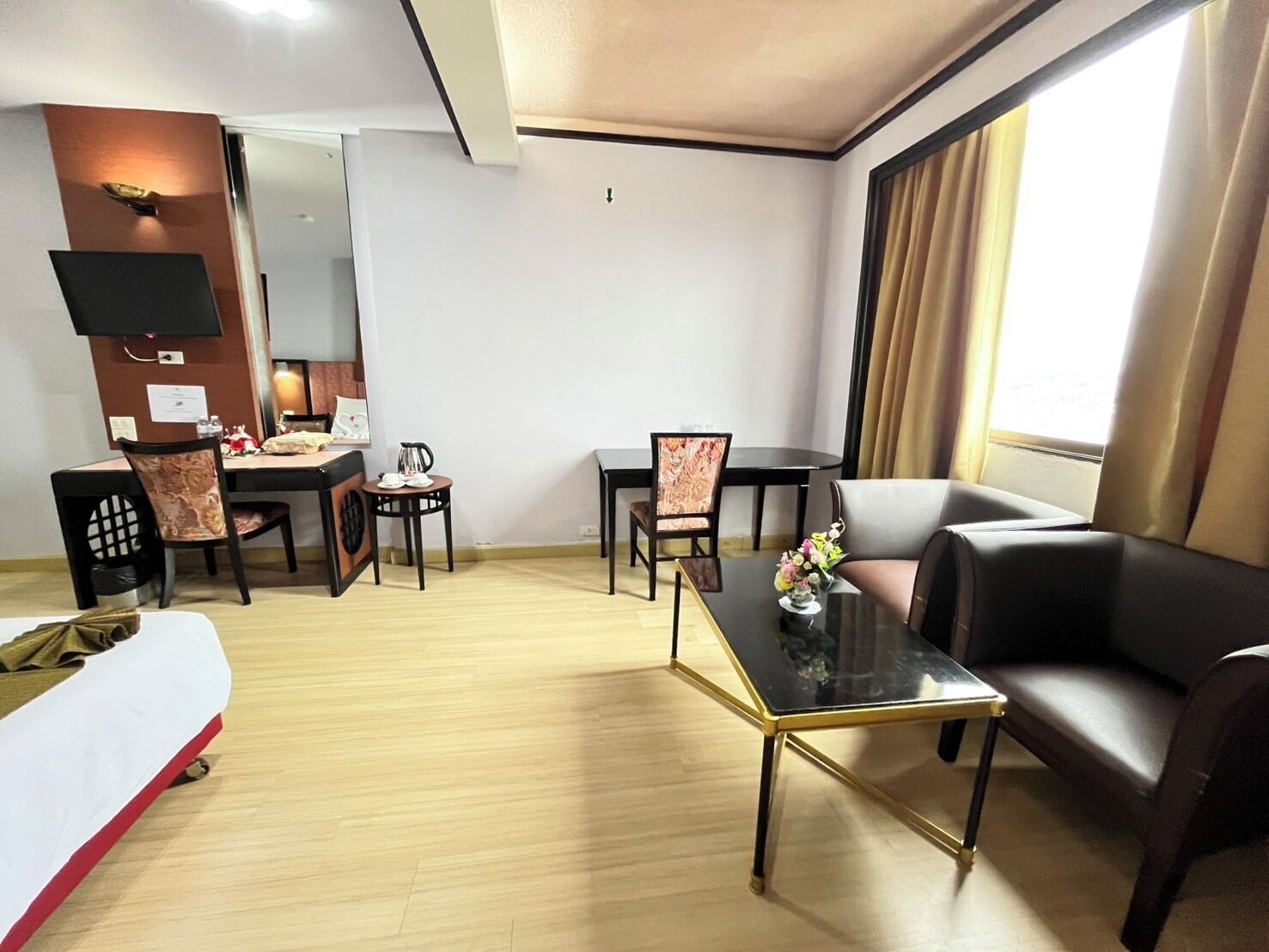 Ein Hotelzimmer mit Essbereich, einer Couch, einem Couchtisch und einem Fernseher.