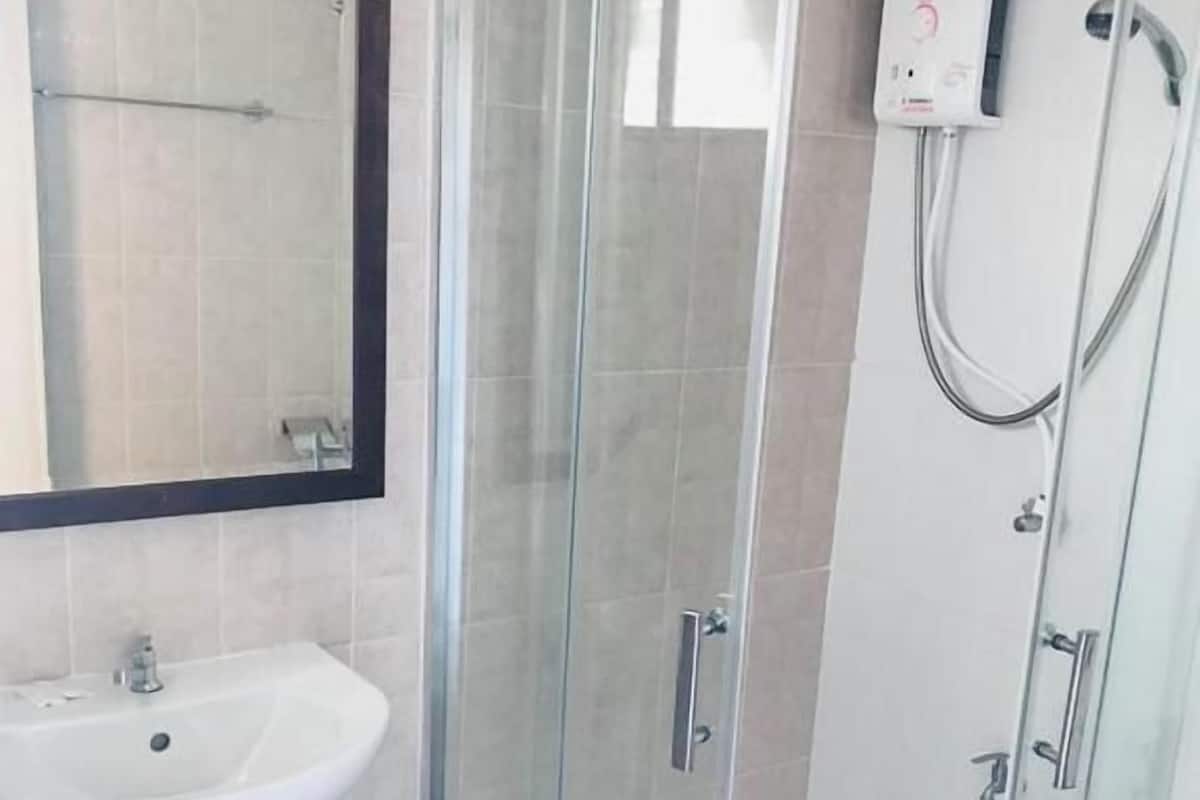 Badkamer | Een bad/douchecombinatie, gratis toiletartikelen, een haardroger