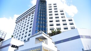 Een hotel met een modern ontwerp, herkenbaar aan de opvallende verticale glazen gevel en een bord met de tekst BP Grand Tower Hotel.