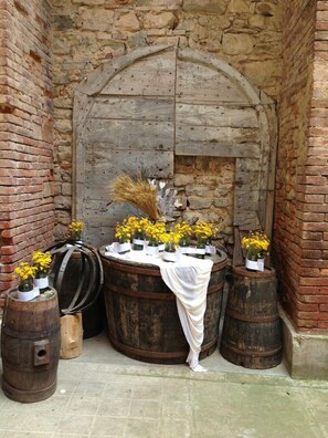 Un entorno rústico con una puerta de madera y barriles, probablemente parte de un edificio histórico.