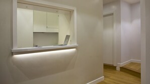 A modern interior with a built-in shelf holding a laptop, a white wall, and a wooden floor. - Domus Giulio Cesare (Rome)