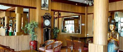 A spacious lobby with wooden paneling, a large clock, and several seating areas.