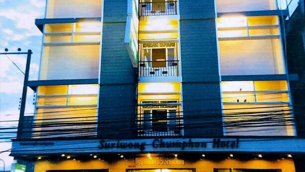 Un edificio de varios pisos con un cartel que dice 'Surinong Chiang Mai Hotel'.