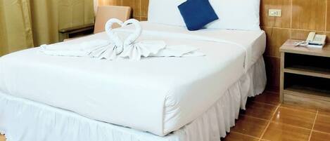 A hotel room with a bed, a nightstand, a telephone, and a painting on the wall.
