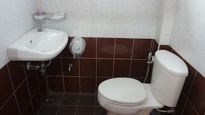 Un baño con lavamanos blanco, inodoro y ducha.