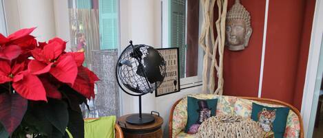 A cozy living area with wicker furniture, a globe lamp, and a Buddha statue.