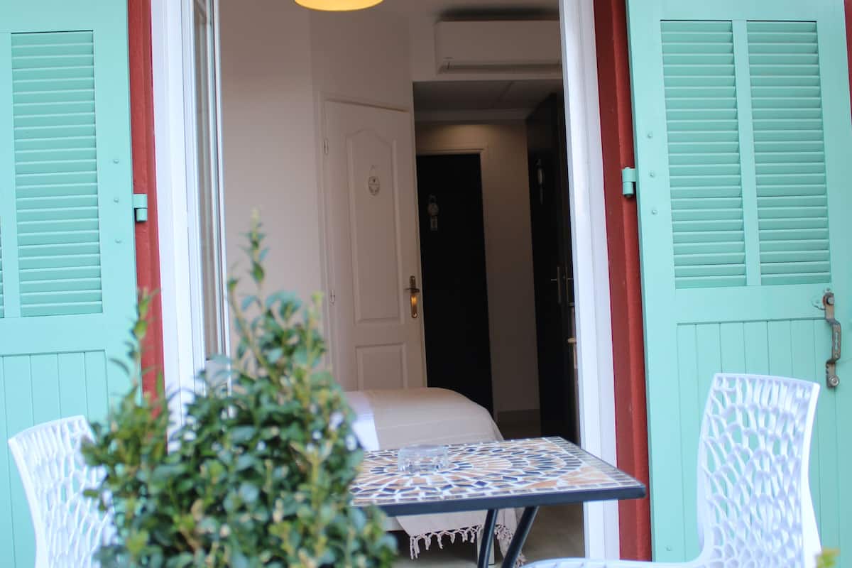 Une pièce comprenant une table et deux chaises, une porte et un luminaire suspendu.